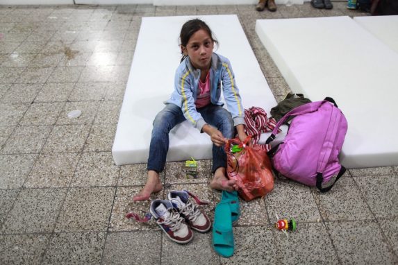 Una niña, unos tenis viejos, unas sandalias de plástico, un jugo en caja y un triste juguete en el piso de granito. La menor hondureña toma un descanso luego de un largo camino entre Chiquimula y la Ciudad de Guatemala.